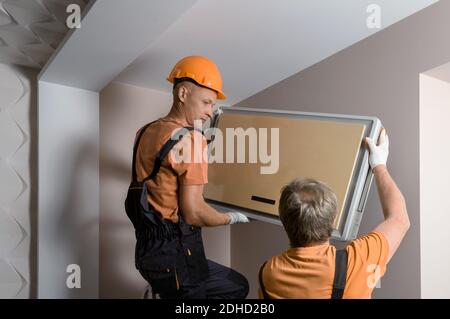 Arbeiter installieren ein Split-System für eine Klimaanlage zu Hause. Stockfoto
