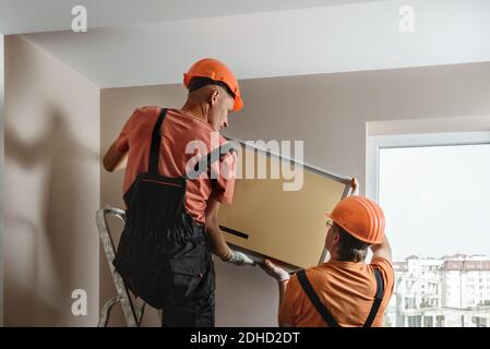 Arbeiter installieren ein Split-System für eine Klimaanlage zu Hause. Stockfoto