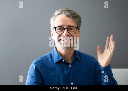 Lächelnder Mann Winkt Hallo In Der Videokonferenz Stockfoto