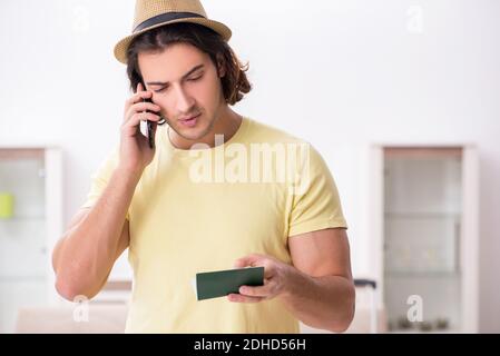 Junger Mann mit Pass für die Vorbereitung der Sommerreise Stockfoto