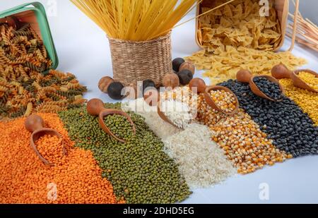 Bunt gemischtes Getreide und Hülsenfrüchte: Reis, Nudeln, Linsen, Bohnen, Kichererbsen auf weißem Hintergrund. Draufsicht. Leeres Leerzeichen für Text. Stockfoto