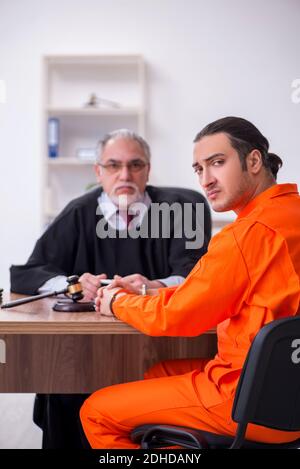 Alte männliche Richter Treffen mit jungen Gefangenen im Gerichtsgebäude Stockfoto