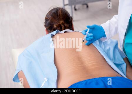 Junge Rücken verletzten Mann Besuch weibliche Arzt Chiropraktiker Stockfoto