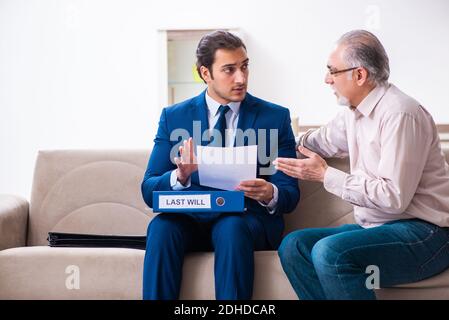 Junger männlicher Anwalt besucht alten Mann in Testament Konzept Stockfoto