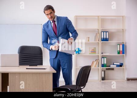 Junger männlicher Angestellter sitzt im Büro vor Whiteboard Stockfoto