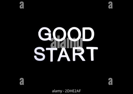 Eine Inschrift 'Good Start' geschrieben mit weißen Buchstaben aus Schaumstoff auf schwarzem Hintergrund, Motivation für einen guten Start in den Tag Stockfoto