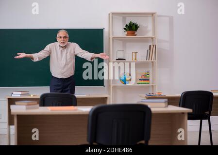 Alter männlicher Lehrer vor der Tafel Stockfoto