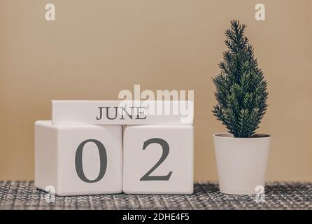 Tischkalender für die Verwendung in verschiedenen Ideen. Sommermonat - Juni und die Zahl auf den Würfeln 02. Kalender der Feiertage auf einem beigefarbenen soliden Hintergrund. Stockfoto