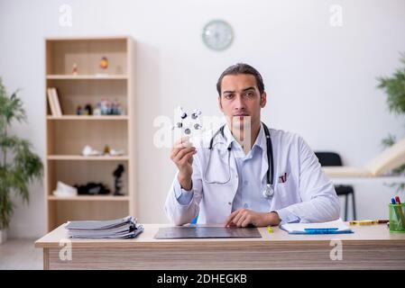 Junger männlicher Arzt studiert molekulares Modell Stockfoto