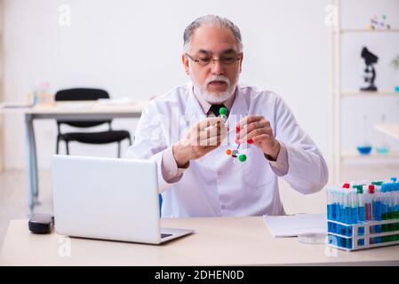 Alter männlicher Wissenschaftler, der molekulares Modell studiert Stockfoto