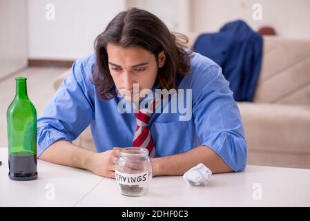 Junger männlicher Angestellter, der von seiner Arbeit zu Hause entlassen wurde Stockfoto