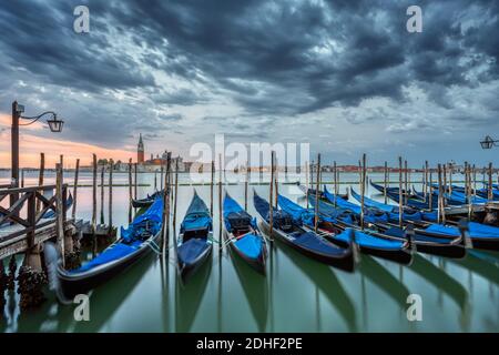 Gondeln auf dem Markusplatz in Venedig, Italien, bei einem dramatischen Sonnenaufgang Stockfoto