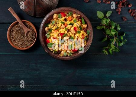 Marokkanischer Couscous mit Zutaten, Decke flach auf einem dunklen Hintergrund erschossen Stockfoto