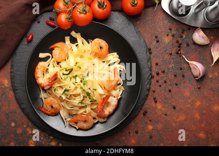 Teller mit leckeren Nudeln mit Garnelen auf dem Tisch Stockfoto