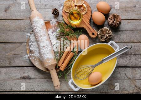 Zutaten für Weihnachtsbäckerei und Küchenutensilien auf Holzhintergrund Stockfoto