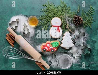 Zutaten für Weihnachtsplätzchen und Backutensilien auf farbigem Hintergrund Stockfoto