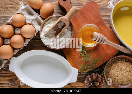 Zutaten für Weihnachtsbäckerei und Küchenutensilien auf Holzhintergrund Stockfoto