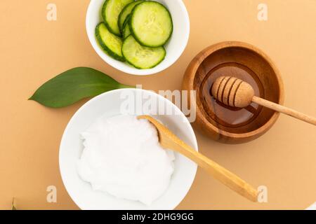 Schüsseln mit Joghurt, Gurke und Dressing auf gelbem Hintergrund Stockfoto