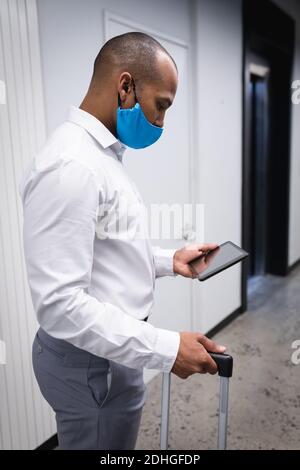 Gemischter Mann mit Gesichtsmaske in einem Büro Stockfoto
