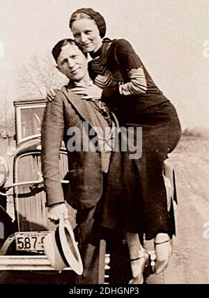 Bonnie Parker und Clyde Barrow, irgendwann zwischen 1932 und 1934, als ihre Exploits in Arkansas Mord, Raub und Entführung beinhalteten. Entgegen der landläufigen Meinung haben die beiden nie geheiratet. Sie waren in einer langjährigen Beziehung. Posiert vor einem Ford V8-Automobil von 1932. Stockfoto