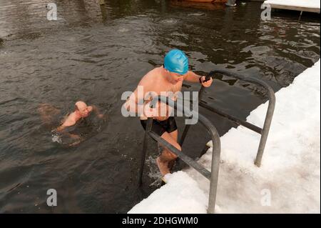 Winterschwimmer, trotzt Schnee und Eis für ihr tägliches Schwimmen im Highgate Men's Bathing Pond, Hampstead Heath, London, Großbritannien. Januar 2010 Stockfoto