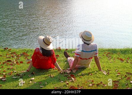 Ein Paar im Strohhut, das sich am See entspannt Stockfoto