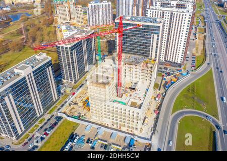 Luftaufnahme von Glashäusern mit Wohnungen, einem Komplex von Häusern im Bau und einem städtischen Wohngebiet von Hochhäusern Stockfoto