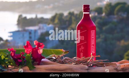 VOLOS, GRIECHENLAND - 30. Nov 2020: Skiathos Island, Griechenland, Flasche Johnnie Walker Red, Blended Scotch Whiskey, bei Sonnenuntergang. Stockfoto