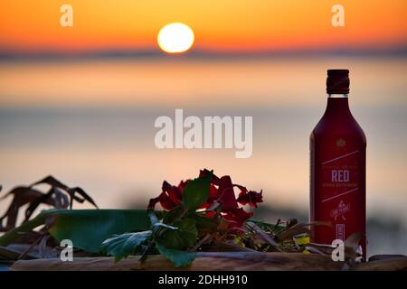 VOLOS, GRIECHENLAND - 30. Nov 2020: Skiathos Island, Griechenland, Flasche Johnnie Walker Red, Blended Scotch Whiskey, bei Sonnenuntergang. Stockfoto