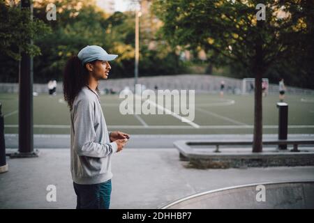 Seitenansicht eines durchdachten Mannes, der im Skateboard Park steht Stockfoto