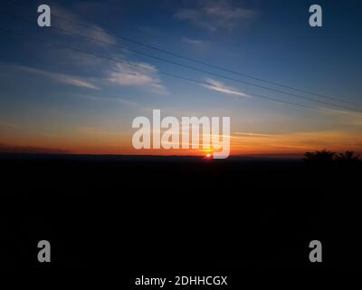 Orangefarbener Sonnenuntergang mit klarem Cky. Großer Horizont. Offenes Feld Stockfoto