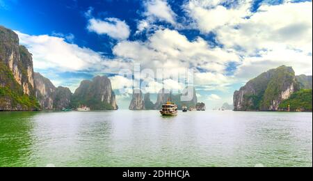 Dreamy sunset in Halong bay, Vietnam. Tourist cruise ship floating among limestone rocks. This is the UNESCO World Heritage Site, Stock Photo