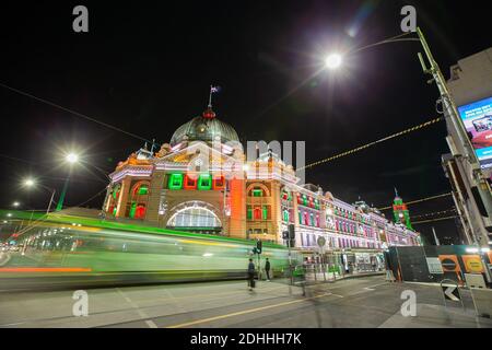 Melbourne, Australien. Dezember 2020. Melbourne, Melbourne Town Hall und Princes Bridge ab November 27. Januar 2021. Dieses Langzeitbelichtungsfoto zeigt die weihnachtlichen Lichtprojektionen am Bahnhof Flinders Street in Melbourne, Australien, am 10. Dezember 2020. Melbournes beliebte Weihnachtsprojektionen decken einige bedeutende Orte ab, darunter die State Library Victoria, das Melbourne Town Hall und die Princes Bridge vom 27. November 2020 bis 3. Januar 2021. Die Projektionen in der State Library Victoria zeigen eine Dankeswürdigung an Helden, die gegen die COVID-19-Pandemie in der Stadt kämpfen. Stockfoto