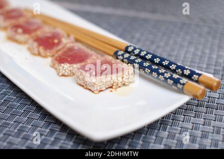 Thunfisch Tataki Stück auf weißem Teller und Tischdecke traditionelle japanische Küche. Stockfoto