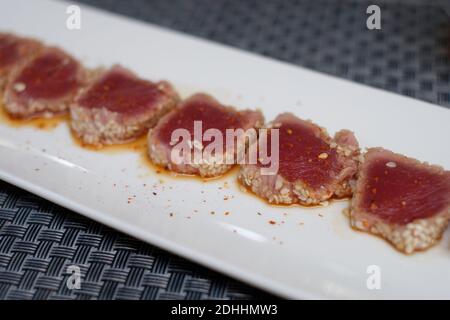 Thunfisch Tataki Stück auf weißem Teller und Tischdecke traditionelle japanische Küche. Stockfoto