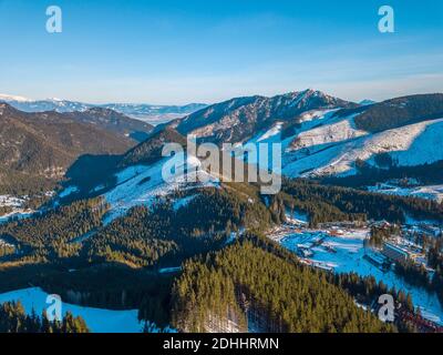 Winter Slowakei. Blauer Himmel. Sonniger Tag im Skigebiet Jasna. Berggipfel und Skipisten. Luftaufnahme Stockfoto