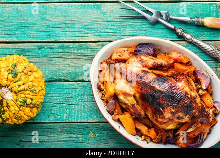 Geröstetes Rebhuhn garniert mit Kürbis auf einem rustikalen Tisch Stockfoto