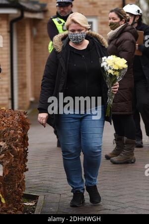 Eine Frau stellt Blumen an die Szene eines Hausfeuers auf Buttercup Avenue, Eynesbury, Cambridgeshire, in dem ein dreijähriger Junge und ein siebenjähriges Mädchen starben. Auch eine 35-jährige Frau und eine 46-jährige wurden bei dem Brand im dreistöckigen Haus verletzt, von dem die Polizei glaubt, dass er gegen 7 Uhr morgens am Donnerstagmorgen ausbrach. Stockfoto