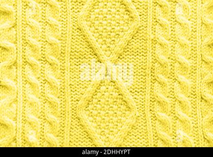 Textur aus gestrickter Handarbeit. Gelber Pullover. Hintergrund oder abstrakter Hintergrund. Draufsicht. Flach liegend. Trendige Farbbeleuchtung des Jahres 2021. Stockfoto