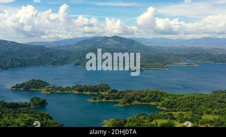 Der blaue Pantabangan Lake inmitten der grünen Berge, die mit grünen Wäldern bedeckt sind. Philippinen, Luzon. Stockfoto