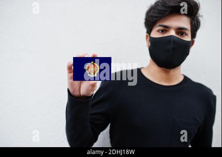 Indonesian Mann tragen ganz schwarz mit Gesichtsmaske halten Special Region von Yogyakarta Flagge in der Hand isoliert auf weißem Hintergrund. Provinzen von Indonesien koron Stockfoto