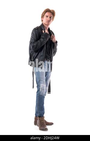 Seitenansicht des selbstbewussten jungen Mannes in Jeans und Stiefeln Anpassung schwarze Lederjacke. Ganzkörperlänge isoliert auf weißem Hintergrund. Stockfoto