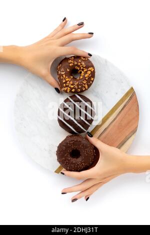 Womans Hände halten Schokolade Donut auf weißem Hintergrund. Modell Vorlage für Bäckerei Stockfoto