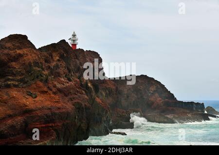 Spanien, Kanarische Inseln, Teneriffa, Felsküste mit Leuchtturm Faro de Teno am Atlantik Stockfoto