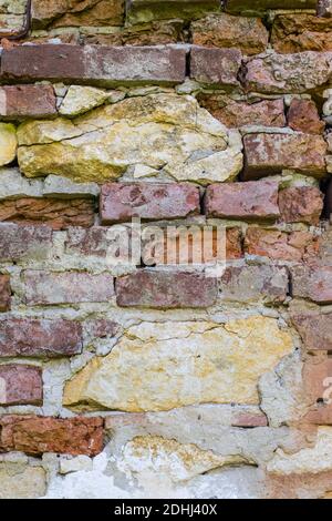 Abstrakte Hintergründe: Alte zerstörte rote Ziegelmauer mit Kalksteinen Stockfoto