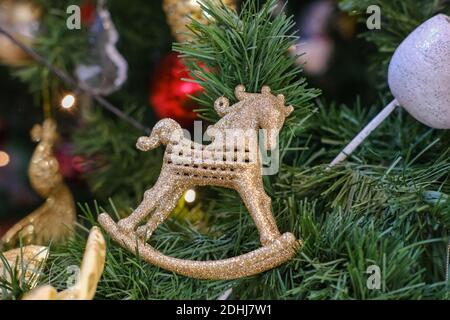 Weihnachtsbaum Spielzeug in Form eines goldenen Pferdes An den Ästen hängen Stockfoto