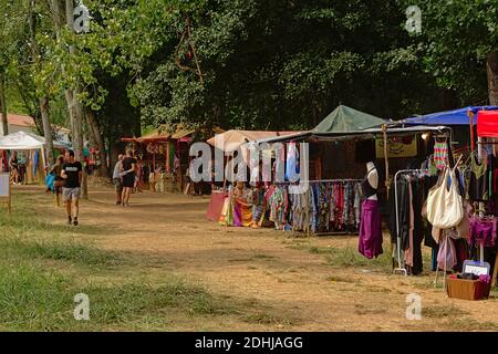 Bunter Markt steht mit Tüchern und Accessoires in der Natur auf einem Musikfestival in la Codosera, Spanien Stockfoto