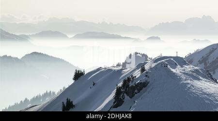 Snow Mountains Panorama im tief liegenden Inversionsnebel. Silhouetten von Nebelbergen. Landschaftlich schöne verschneite Winterlandschaft. Blick von Stuiben nach Saentis Stockfoto