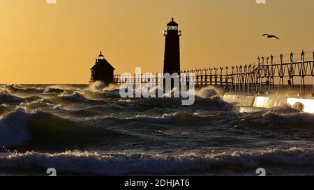 Grand Haven South Pier Leuchtturm bei Sonnenuntergang am Lake Michigan, an einem windigen Tag Stockfoto