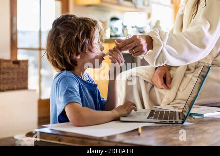 Kleiner Junge zu Hause mit seiner Temperatur mit einem genommen Thermometer Stockfoto